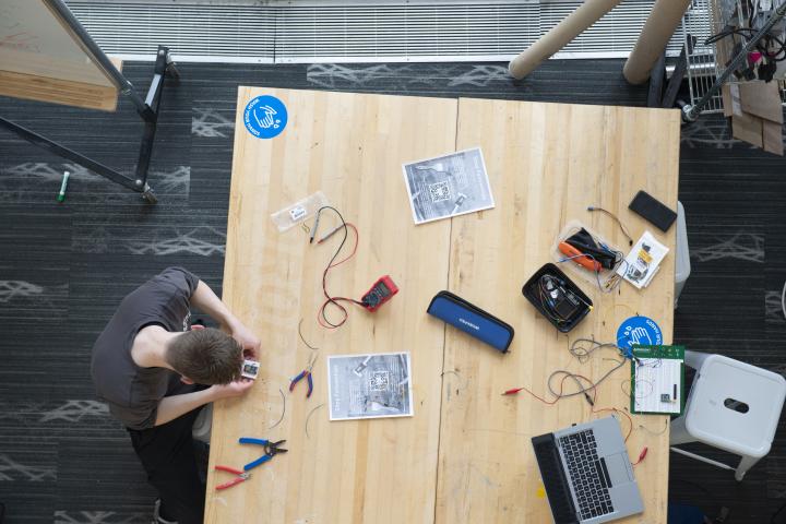 Student working on a project in the academic center shop tables