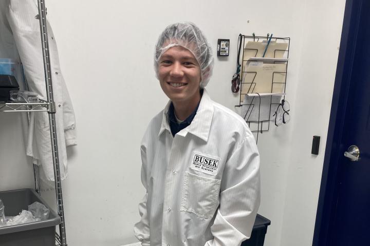 Braden Oh '23 Student Braden Oh '23 in lab safety gear, including white coat and hairnet.