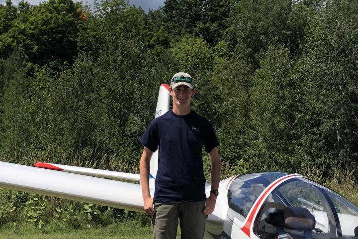 Daniel Burns '25.5 Student Daniel Burns standing next to a small plane.