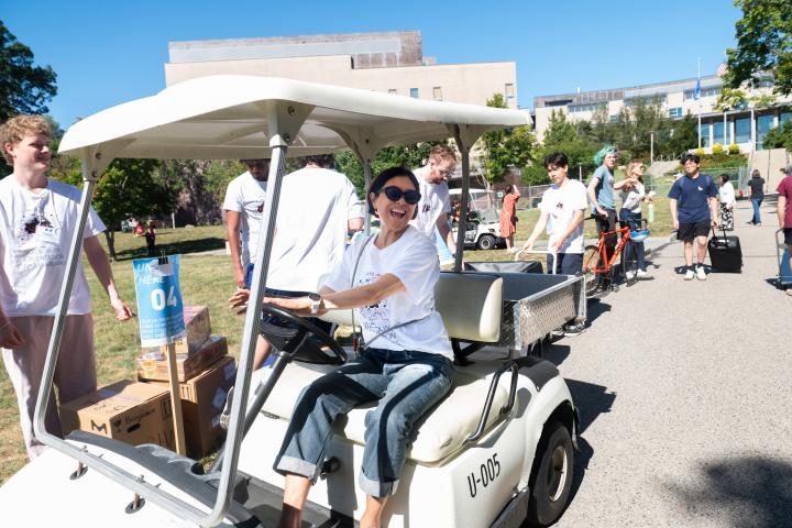 Olin College President May Lee is pictured driving a golf cart at the Class of 2029 Move-In in August 2025.