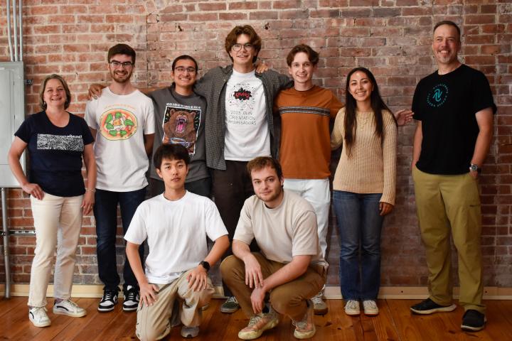 A group of students stand with the owners of Wavelength, a local coffee roaster in Shirley, MA. 