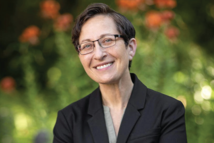 Portrait of Dean Stacey Harris outside surrounded by flowers