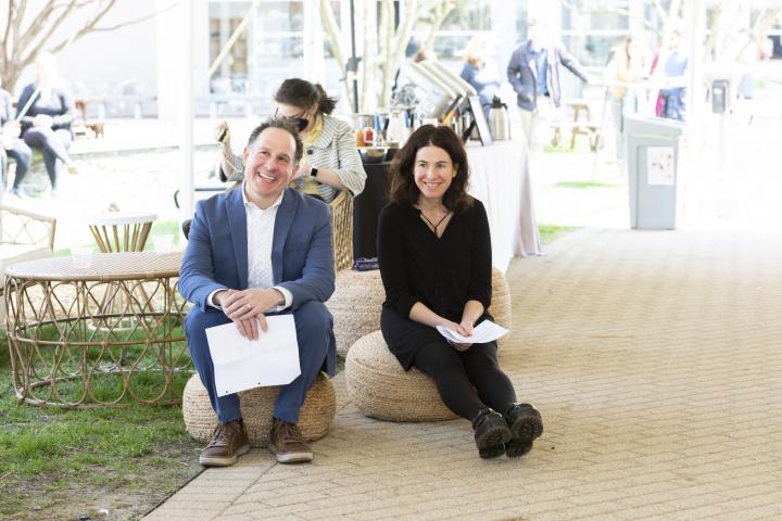 Jon Adler and Gillian Epstein sit and listen to a Story Slam performer.