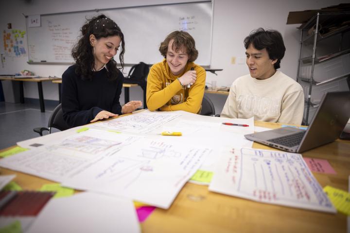 Three Olin College of Engineering students work on a project together in a classroom.