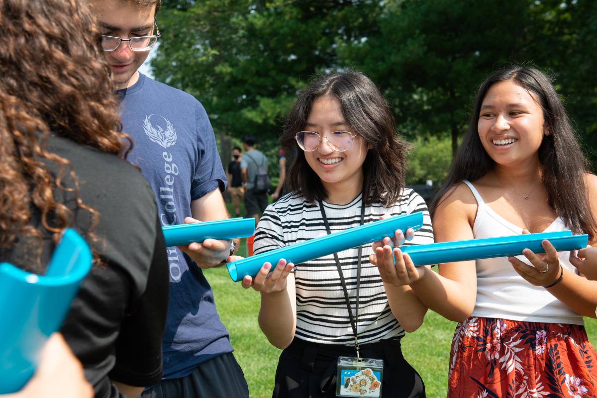 A photo of two Olin students smiling as they work side by side