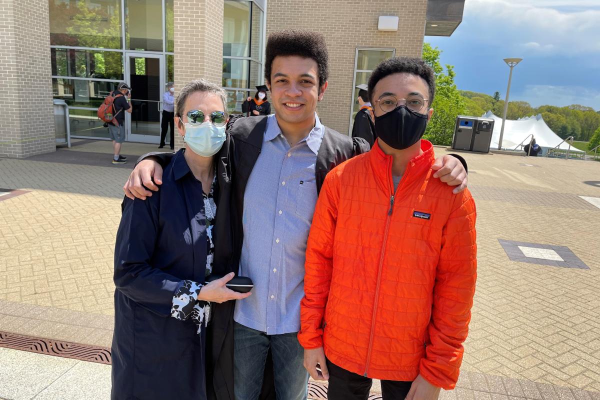 A photo of three people standing outside posing for the camera