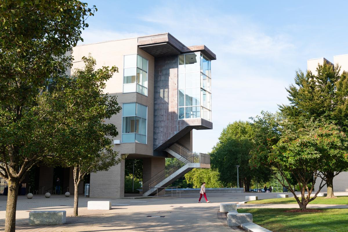 A photo of a three story building surrounded by trees