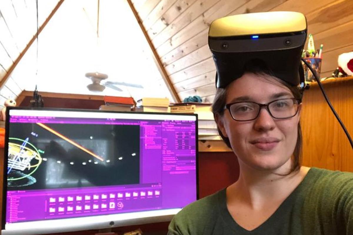 Cali Wierzbanowski ’21 poses with the team's state-of-the-art software and VR headset.