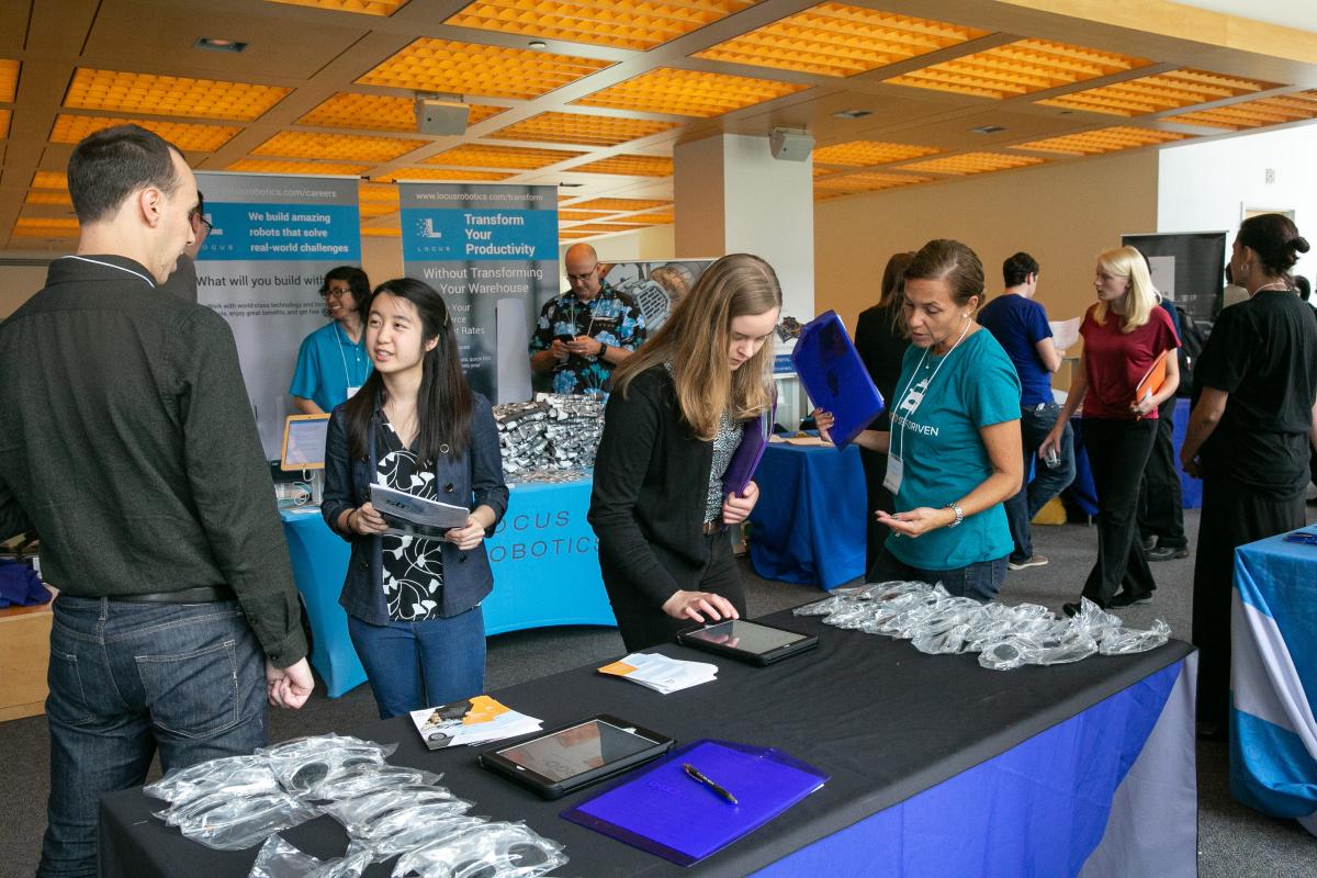 A photo of a group of students and employers mingling at a Career Fair