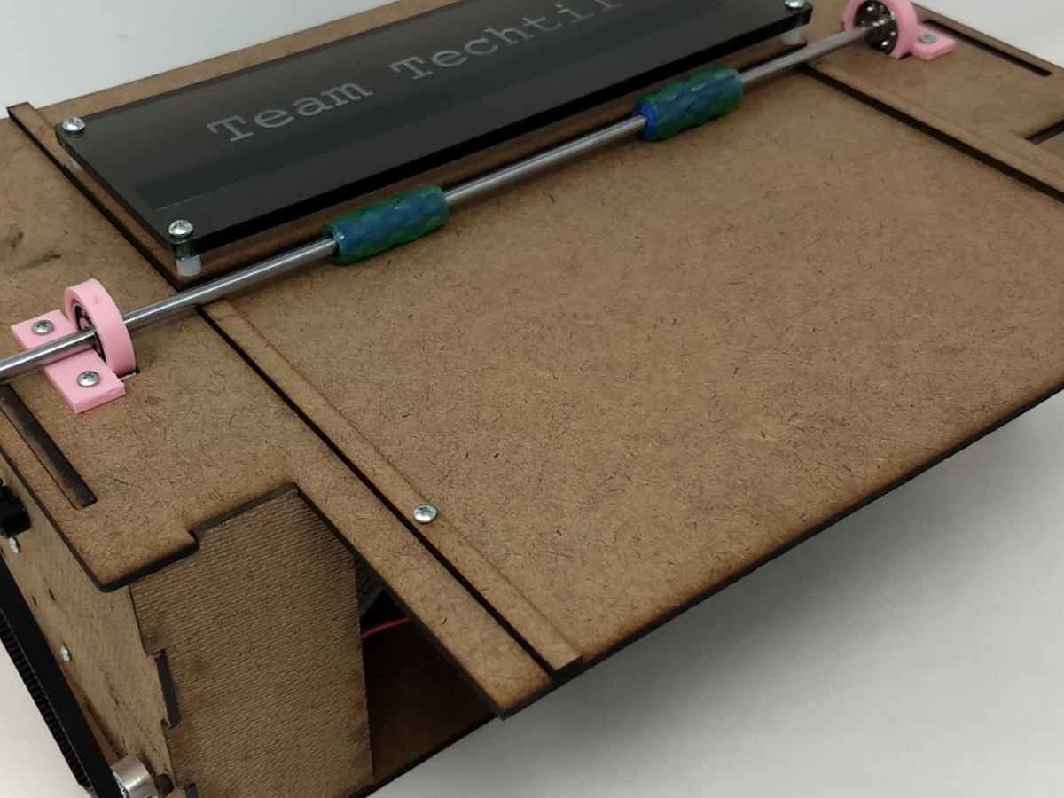 The POE Team's braille printer, Techtile, that converts musical instrument digital interface files into braille sheet music. A brown, printer-looking device with the words "Techtile" stamped across the top.