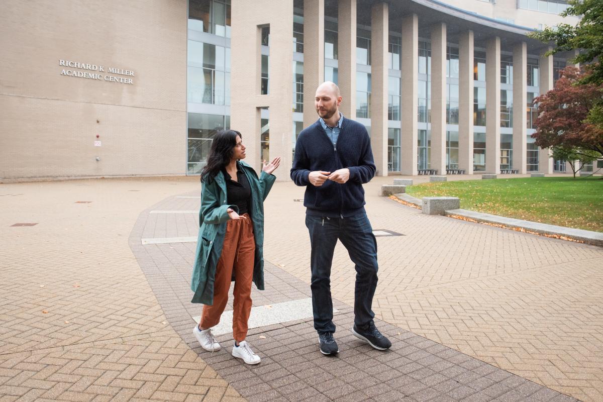 Shreya Chowdhary '22, co-founder of PInT, walks with group advisor and Assistant Professor of Social & Computer Science Erhardt Graeff. Shreya Chowdhary '22, co-founder of PInT, walks with group advisor and Assistant Professor of Social & Computer Science Erhardt Graeff.