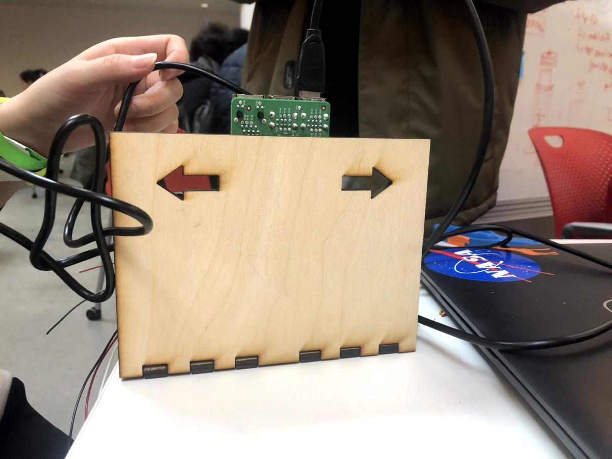 Photo of the Navig8r station by Wesley Soo-Hoo '23 A wooden box with two arrows - one pointing left and one pointing right -carved into it.