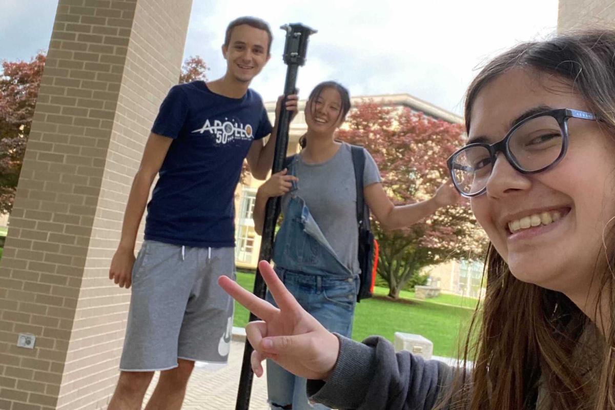 Three members of the Olin Collegiate Amateur Radio Club (OCARC) take a selfie together on the Oval