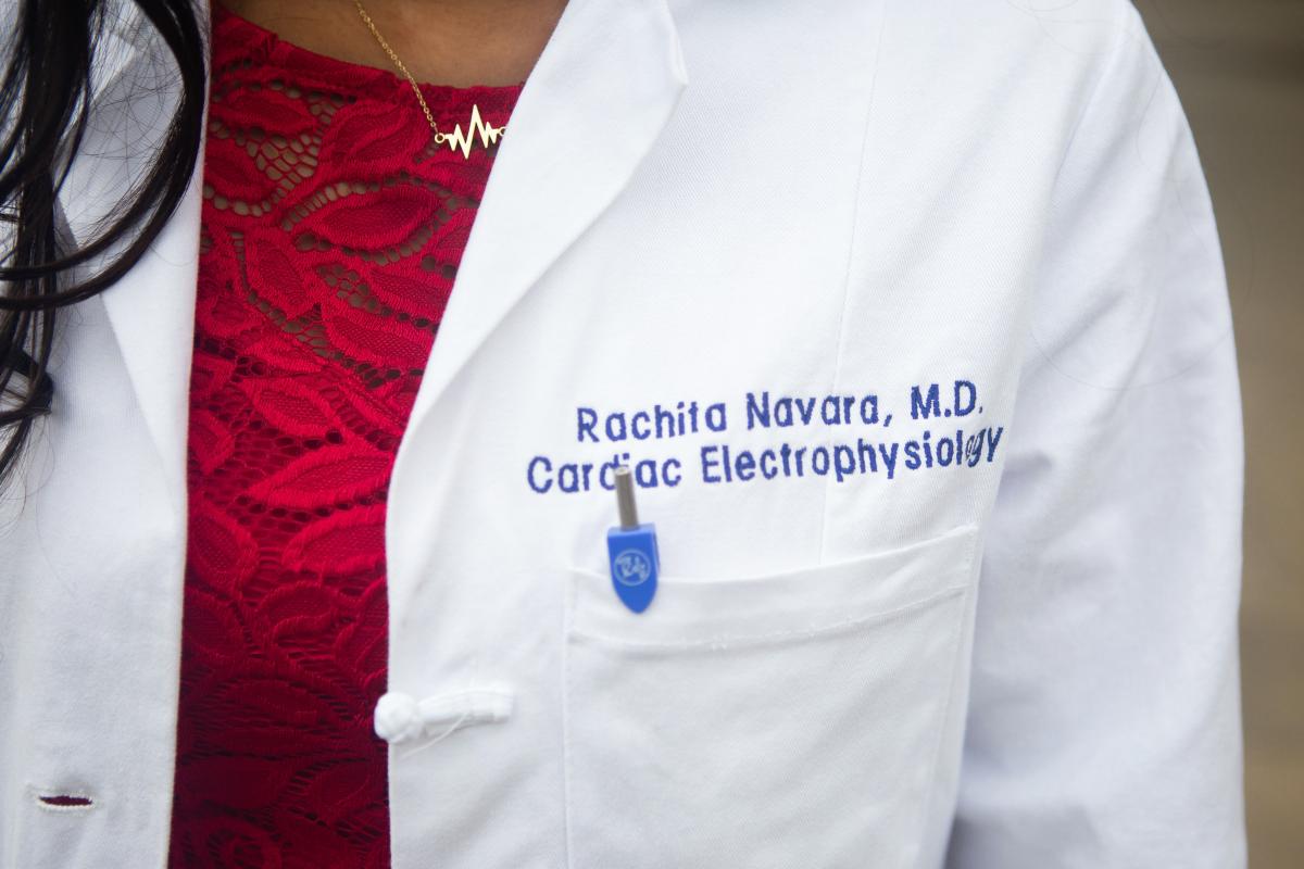 Close-up of Dr. Rachita Navara's lab coat with her name and MD title. Close-up image of a doctor's lab coat with name and MD title listed on it.