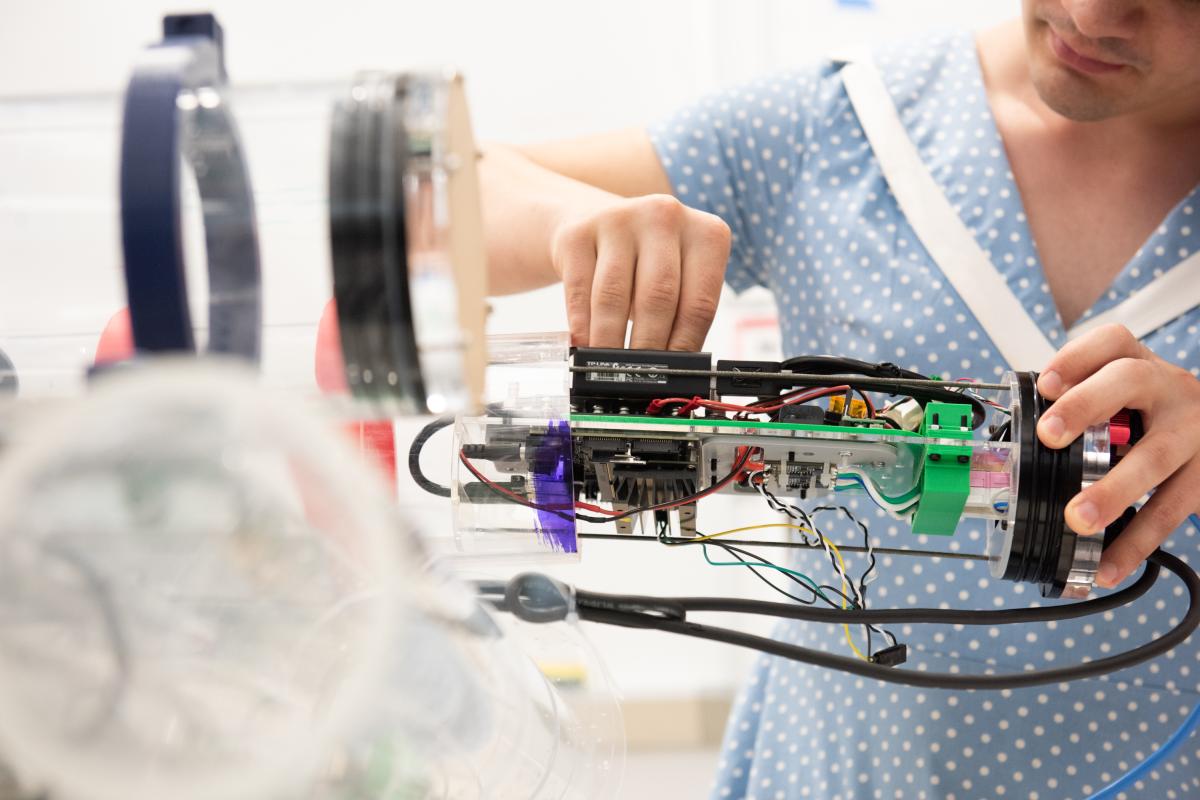 A close-up image of a submersible robot - with wires and different components hanging down and visible. 