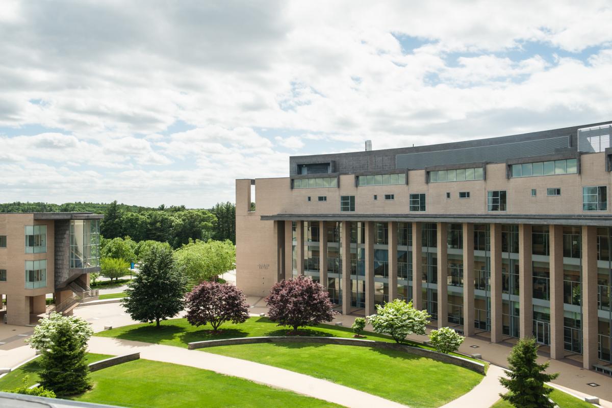 Zoomed out photo of Olin oval and beige building with large windows