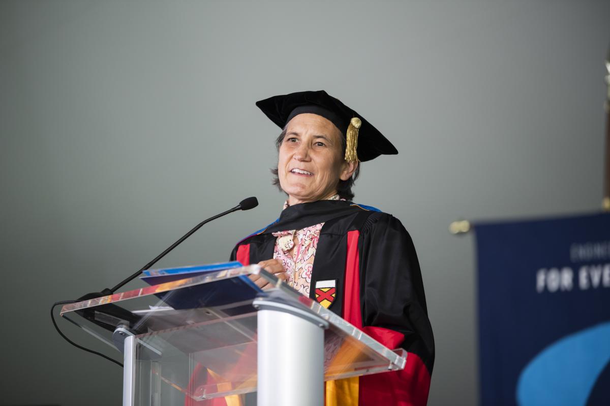 Dr. Linda Vanasupa, Professor of Materials Engineering, speaks to the audience from a podium, on behalf of Olin faculty and staff.