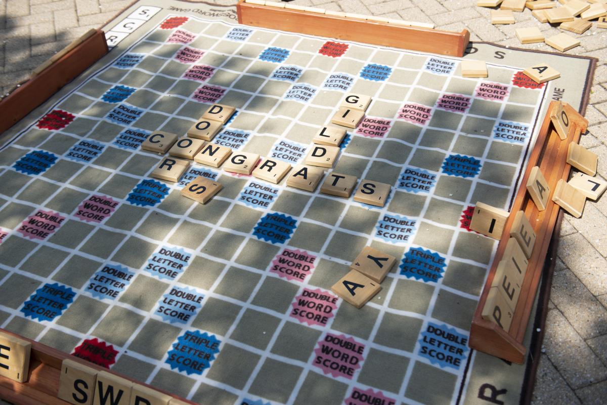 Pieces on a life-sized game of Scrabble spell out the words "Congrats Gilda." 