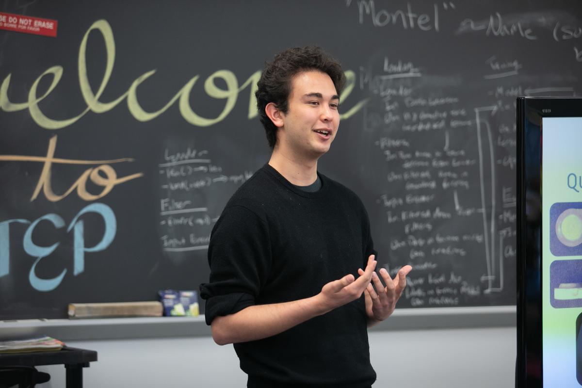 Olin student Eamon Ito-Fisher talks in front of a blackboard during a recent STEP class.