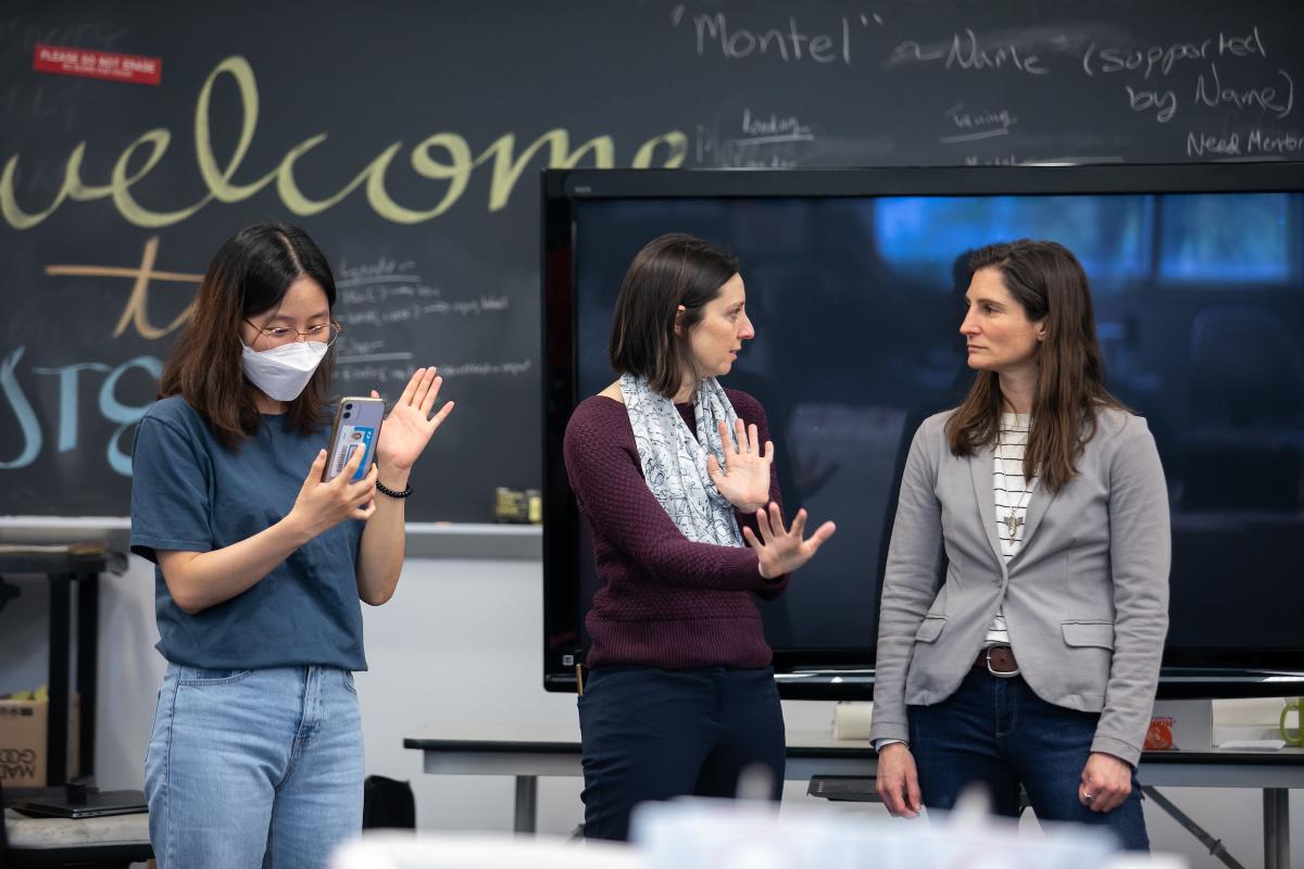 Three members of the Olin College STEP Course talk in a classroom.
