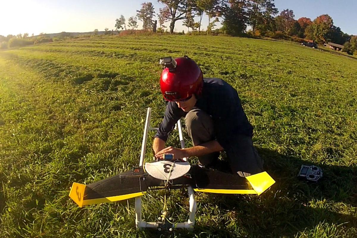 Andy Barry '10 works on an autonomous drone in the field.