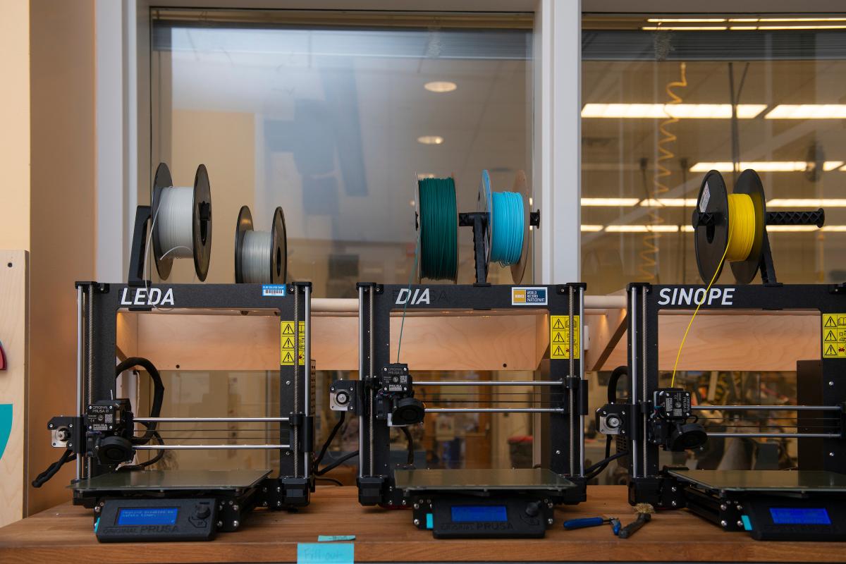 Three 3D printers lined up in a row. Three 3D printers lined up in a row.
