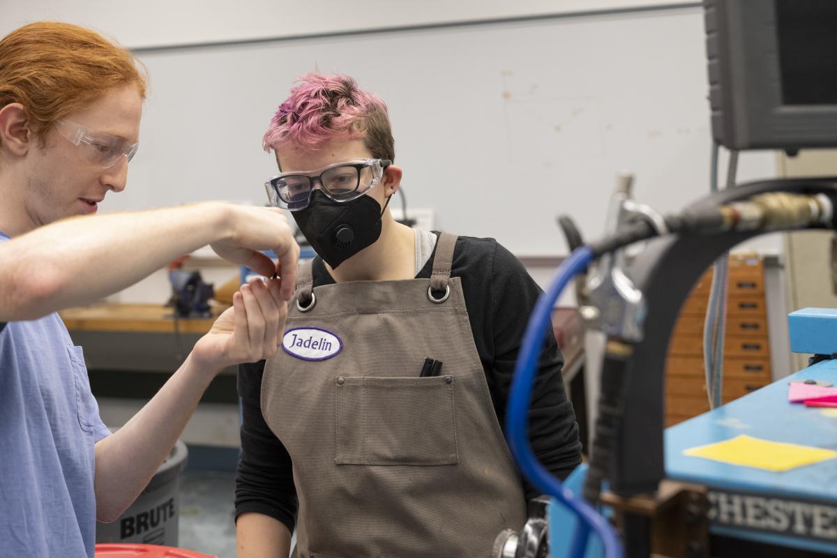 Student Shop Assistant helping fellow peer