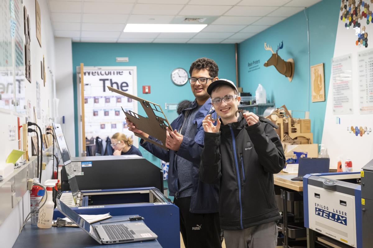 Students holding laser-cut pieces