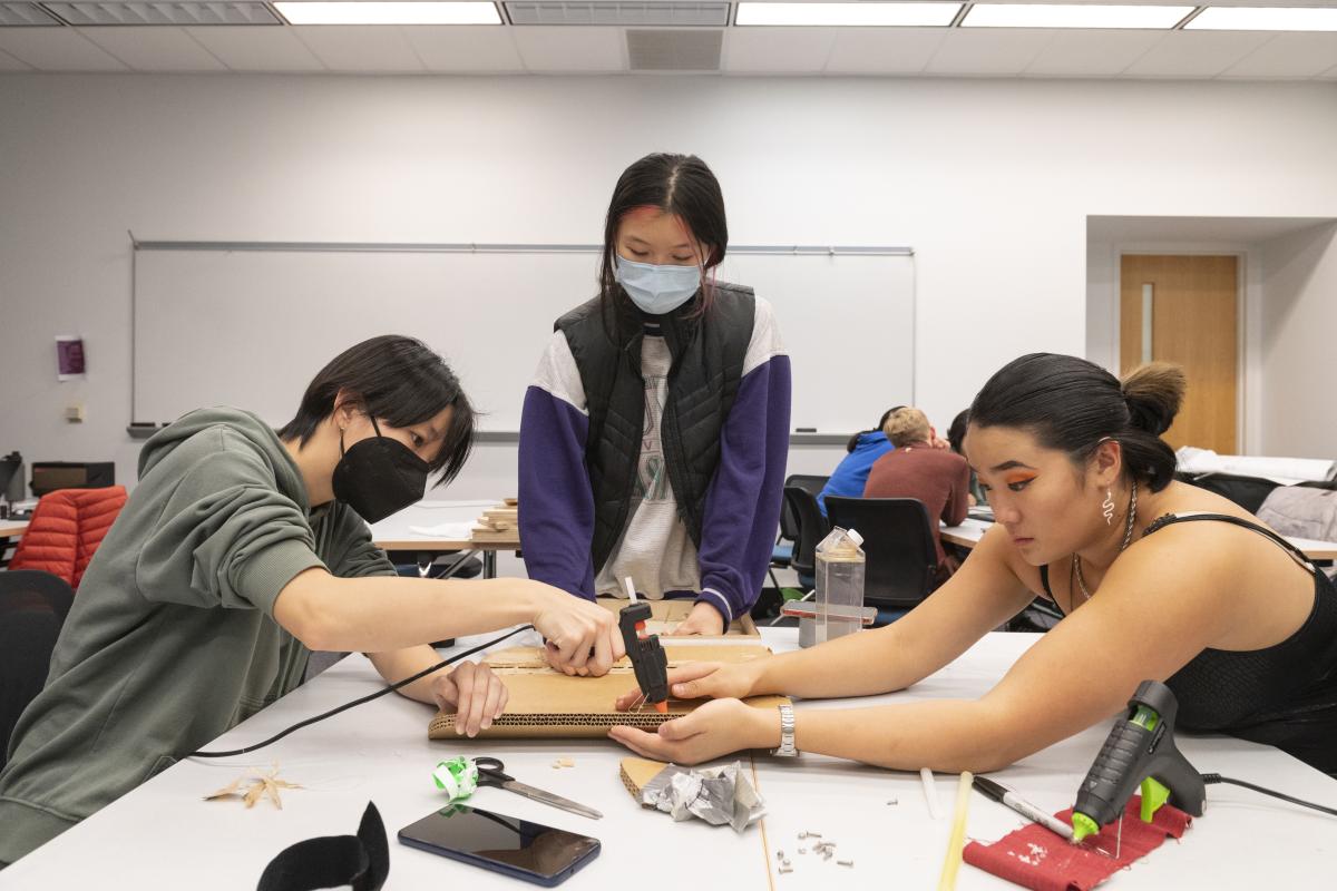 Students constructing prototype Students hot gluing prototype together
