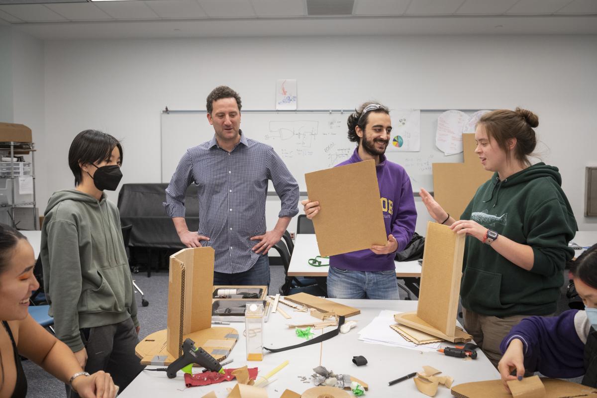 TAD Class in Session Professor Paul Ruvolo and Student Team standing around work table