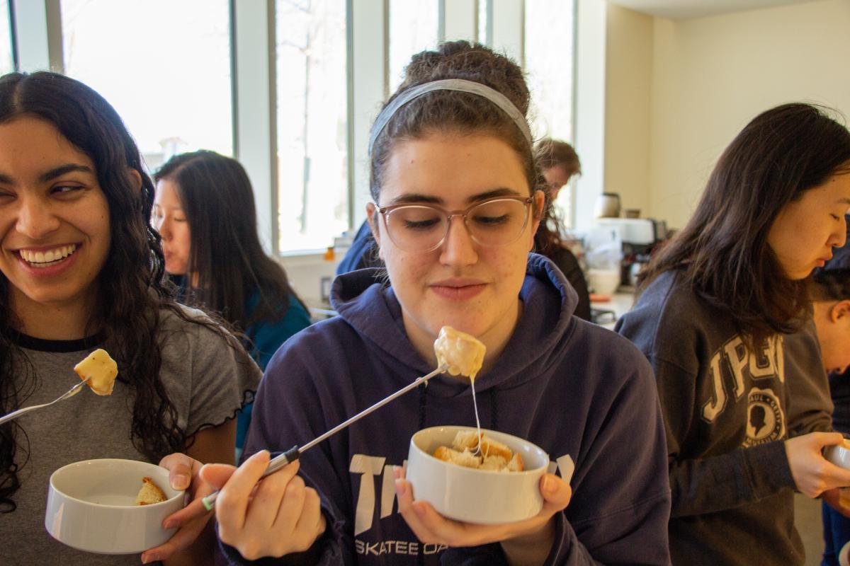 A student enjoys some cheesy fondue during a recent co-curricular session. A student enjoys some cheesy fondue during a recent co-curricular session.