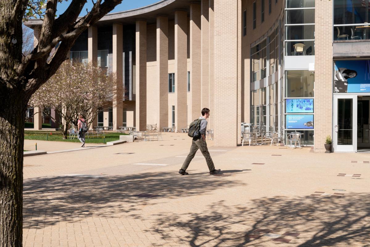 Image of Campus Center with students walking across in early spring