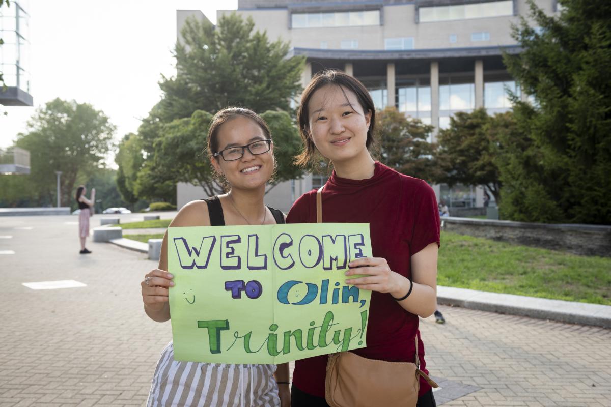 Two students hold up a "Welcome to Olin" sign. Two students hold up a "Welcome to Olin" sign.