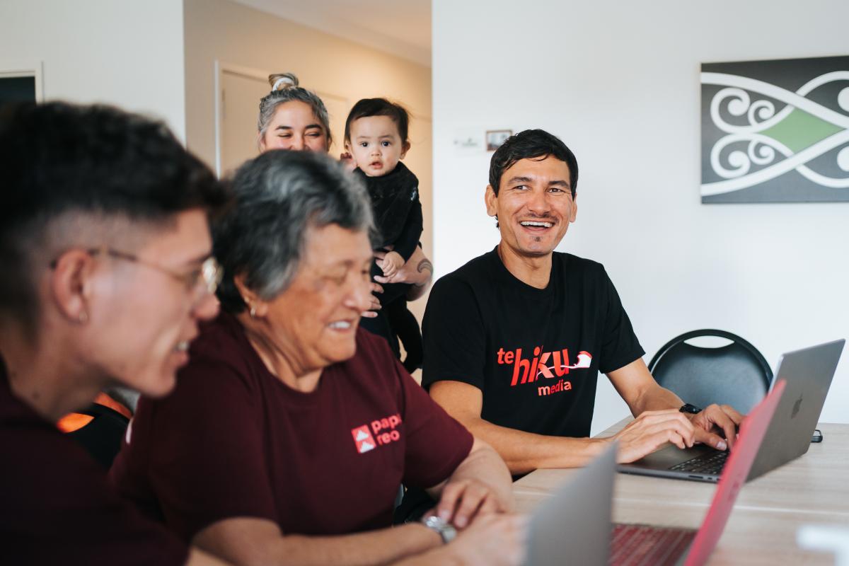 Keoni Mahelona working with community members in the computer