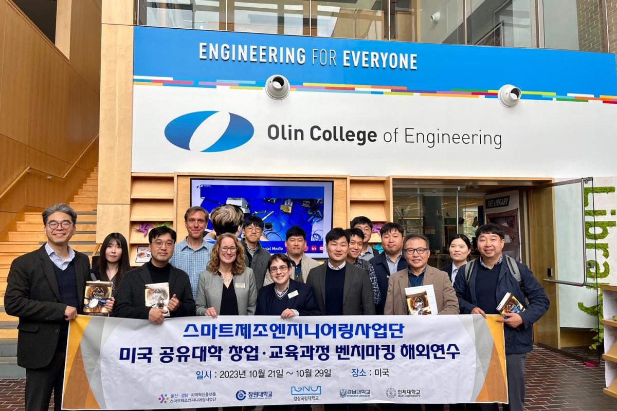 OlinAcademicVisitors Visitors and Olin faculty holding a banner