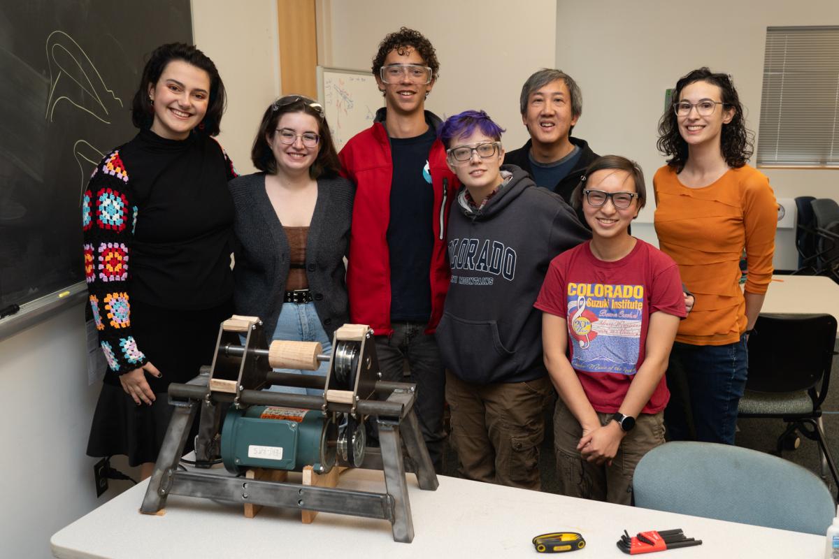 5 Olin students, Professor Chris Lee, and Professor Leah Mendelson posing with the team's final project for Mechanical Design
