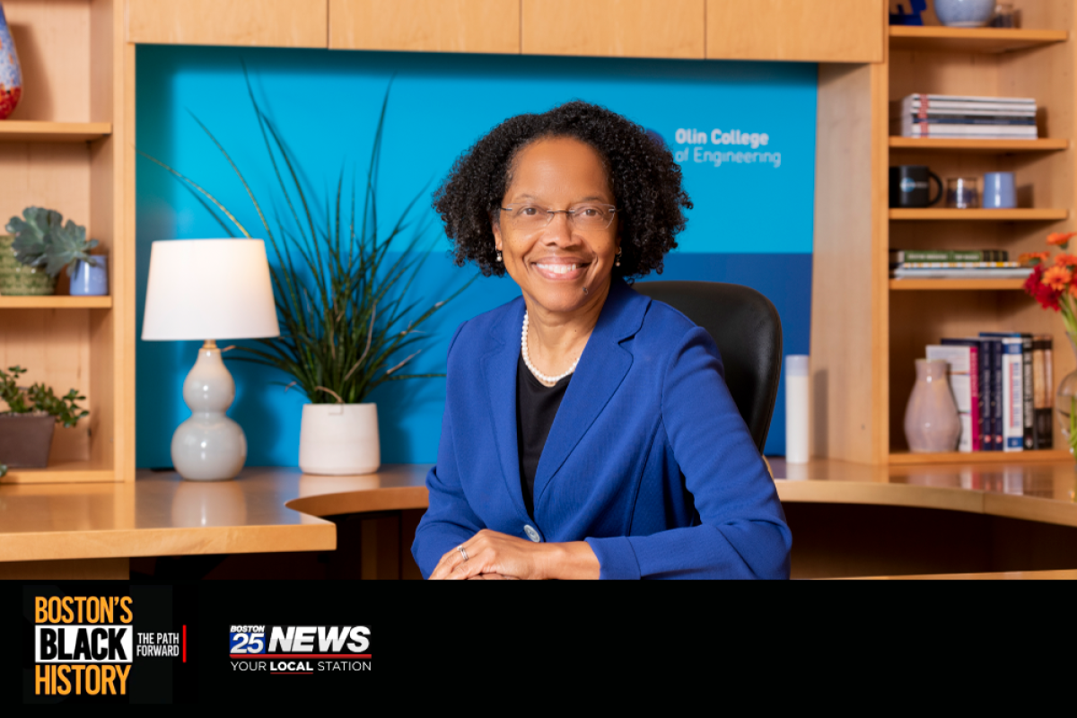 Olin College of Engineering President Gilda Barabino pictured in her office wearing a blue blazer and eyeglasses.