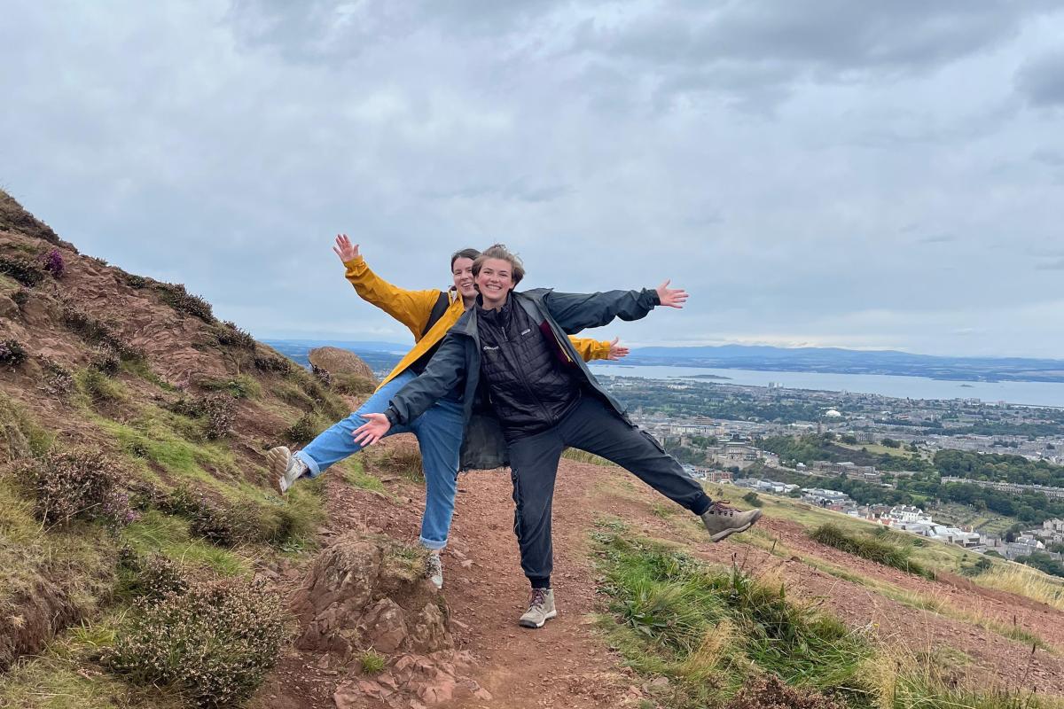 Two college students take a fun photo while visiting Arthur's Seat in Edinburgh, Scotland. 