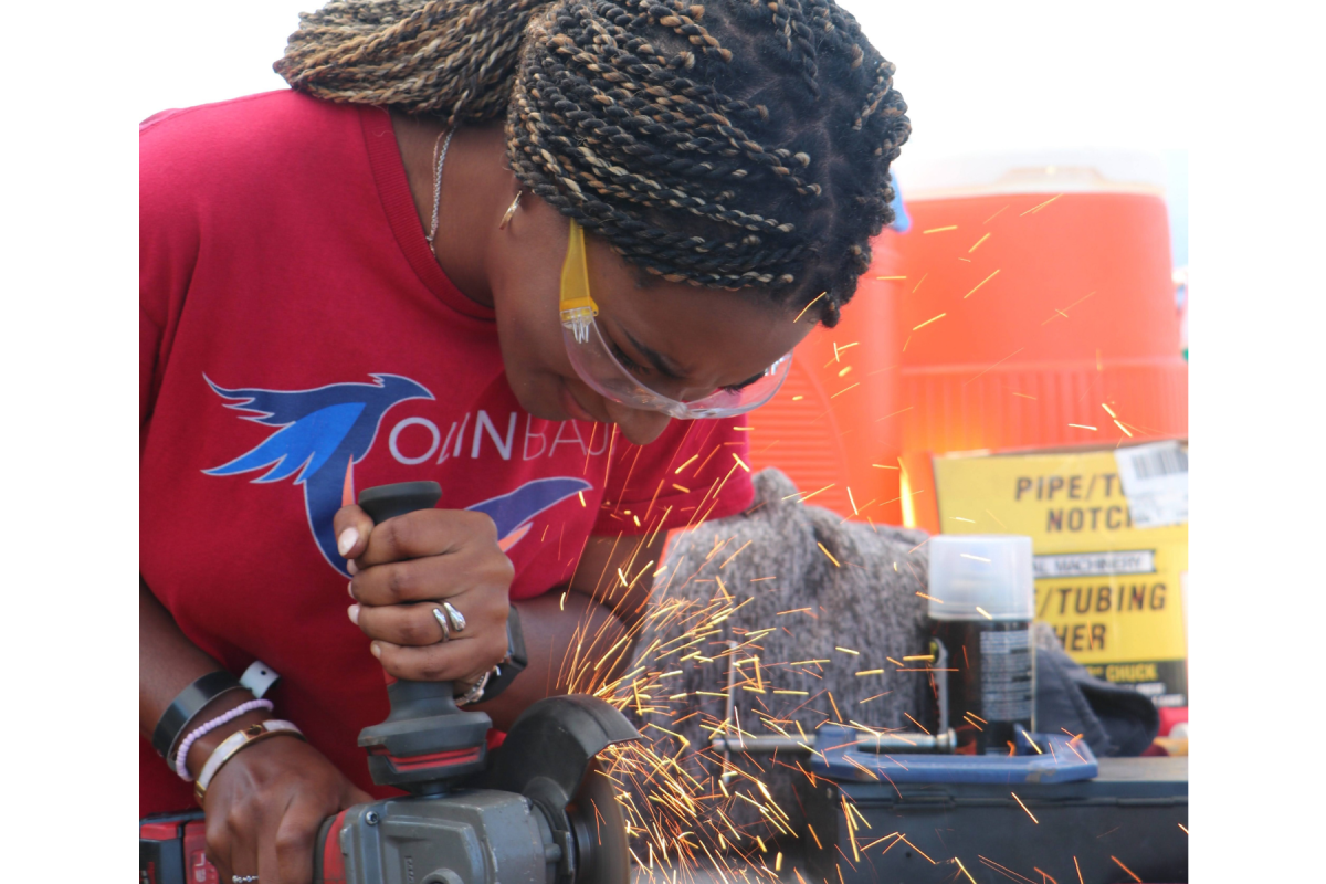 An Olin College student on the Baja project team works with an angle grinder, shooting visible sparks upward. An Olin College student on the Baja project team works with a drill, shooting visible sparks upward.
