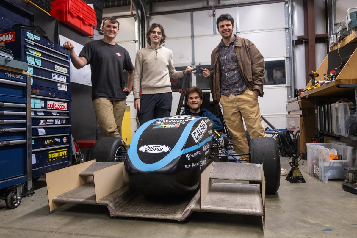 A team of four Olin College students gather around a Formula SAE car which they designed a fully bespoke aerodynamic kit for. A team of four Olin College students gather around a Formula SAE car which they designed a fully bespoke aerodynamic kit for.