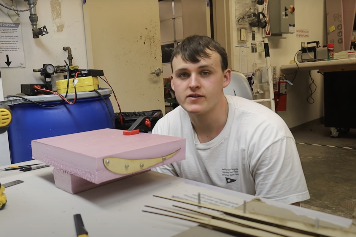 Alton Coolidge '26 seen before fabrication begins and he cuts vehicle wing profiles for a front wing.