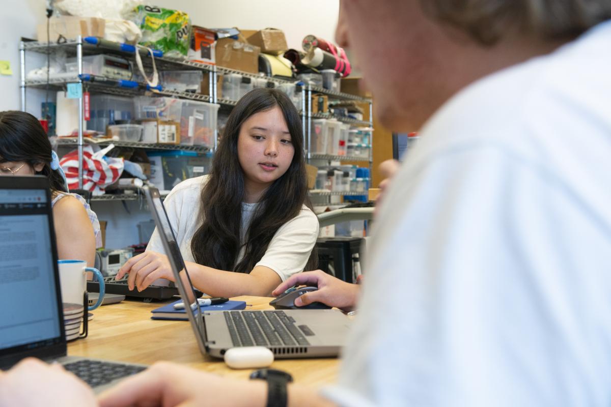 An Olin student looks at a laptop in a classroom.