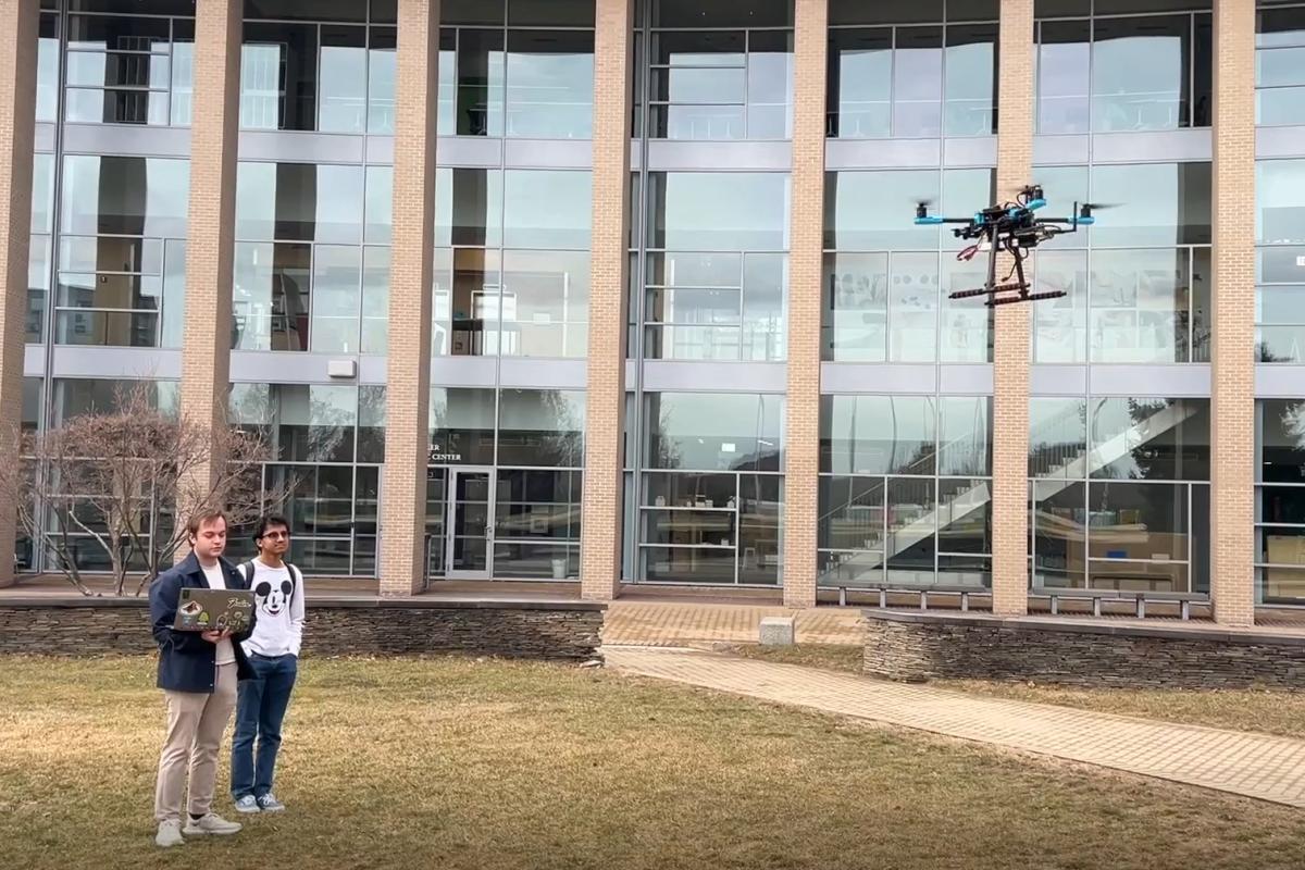 Two student members of the Olin College agricultural robotics research team are shown flying their drone on campus. The drone helps farmers better and more effectively measure and monitor their soil health. Two student members of the Olin College agricultural robotics research team are shown flying their drone on campus. The drone helps farmers better and more effectively measure and monitor their soil health.
