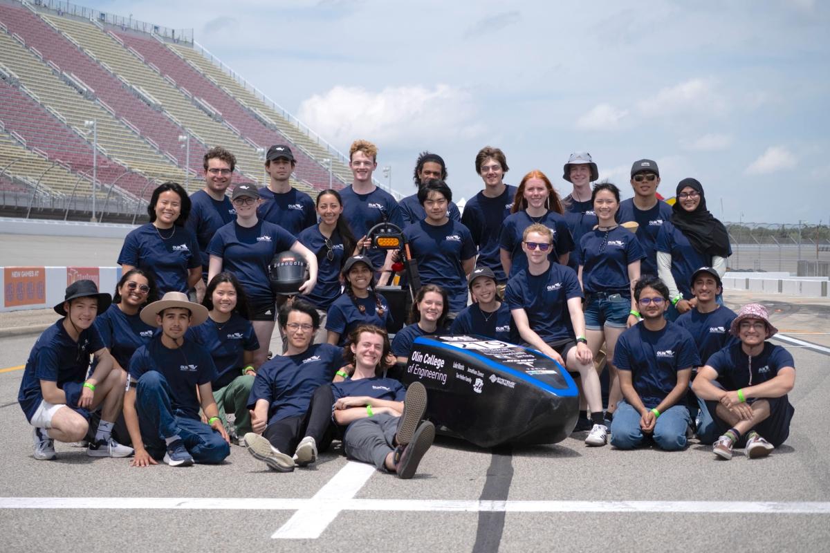 The Olin College of Engineering student project team Olin Electric Motorsports (OEM) pose for a group photo on the race track at a competition this summer. The Olin College of Engineering student project team Olin Electric Motorsports (OEM) pose for a group photo on the race track at a competition this summer.