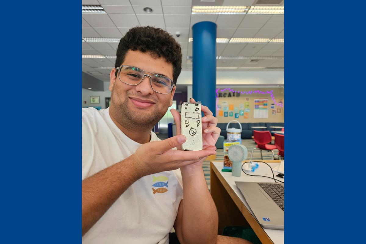 Albert Manrique '25 is pictured at Olin College holding up a reprogrammable hearing testing device user interface prototype. Albert Manrique '25 is pictured at Olin College holding up a reprogrammable hearing testing device user interface prototype.
