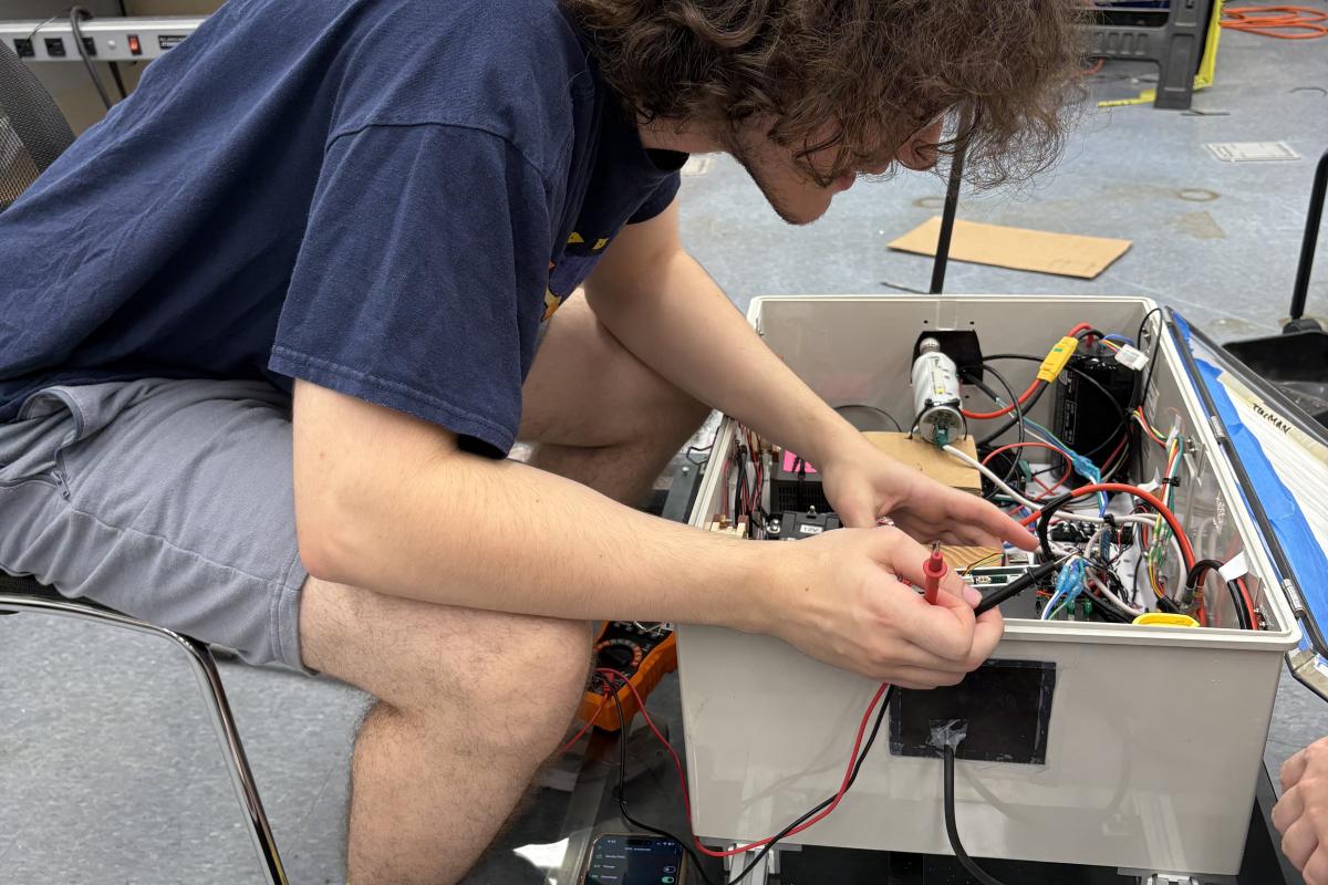 Enzo Smajlaj ’28, an electrical and computer engineering major, is seen wiring and integrating the electrical box and enclosure that'll allow their boat to move. Enzo Smajlaj ’28, an electrical and computer engineering major, is seen wiring and integrating the electrical box and enclosure that'll allow their boat to move.