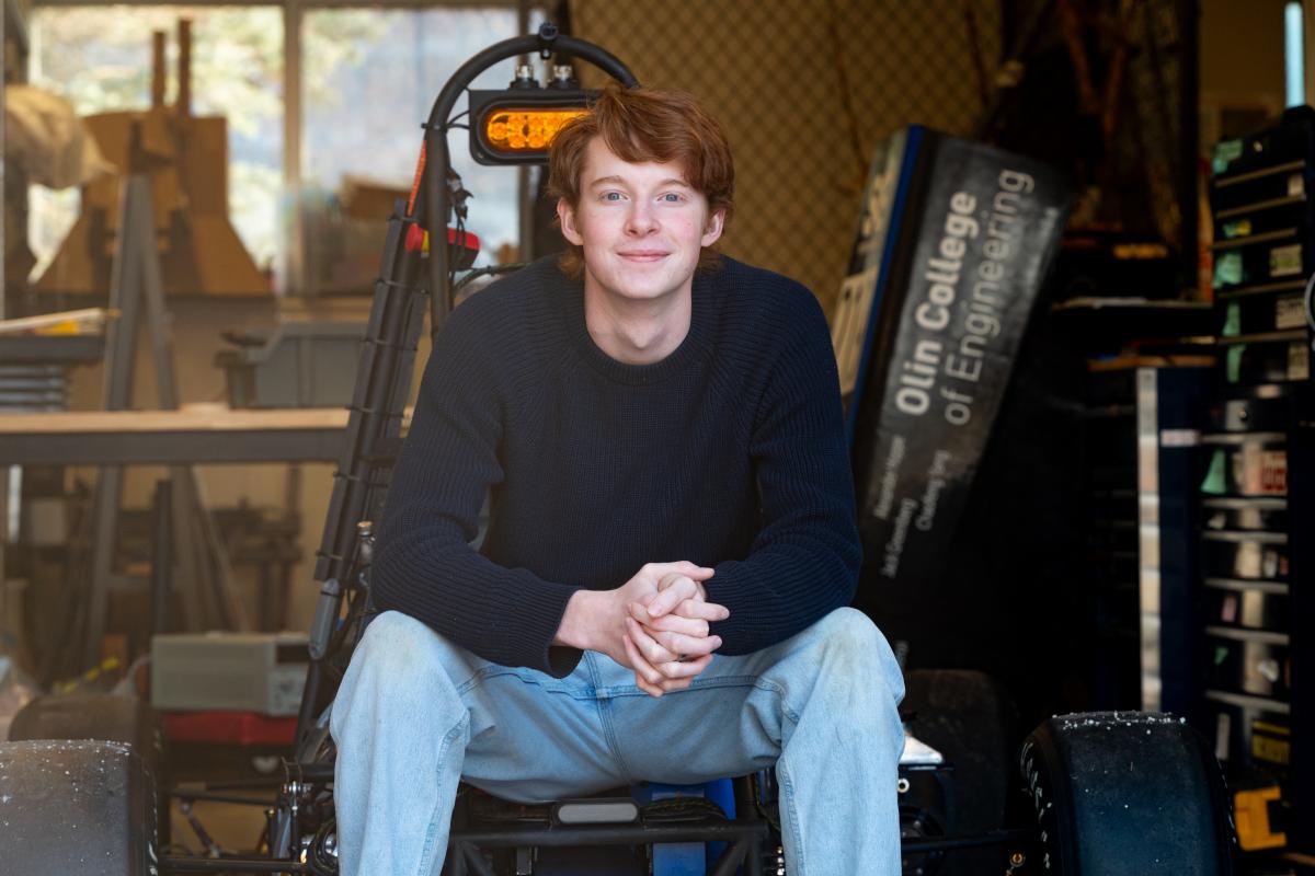 Jake Hamilton ’28 sits on one of Olin OEM's cars. 