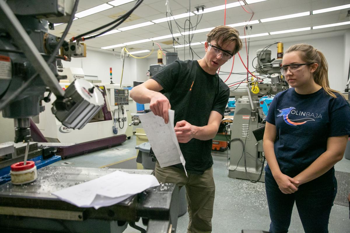 Members of the Olin Baja team look at a design while working in the Machine Shop at Olin College.