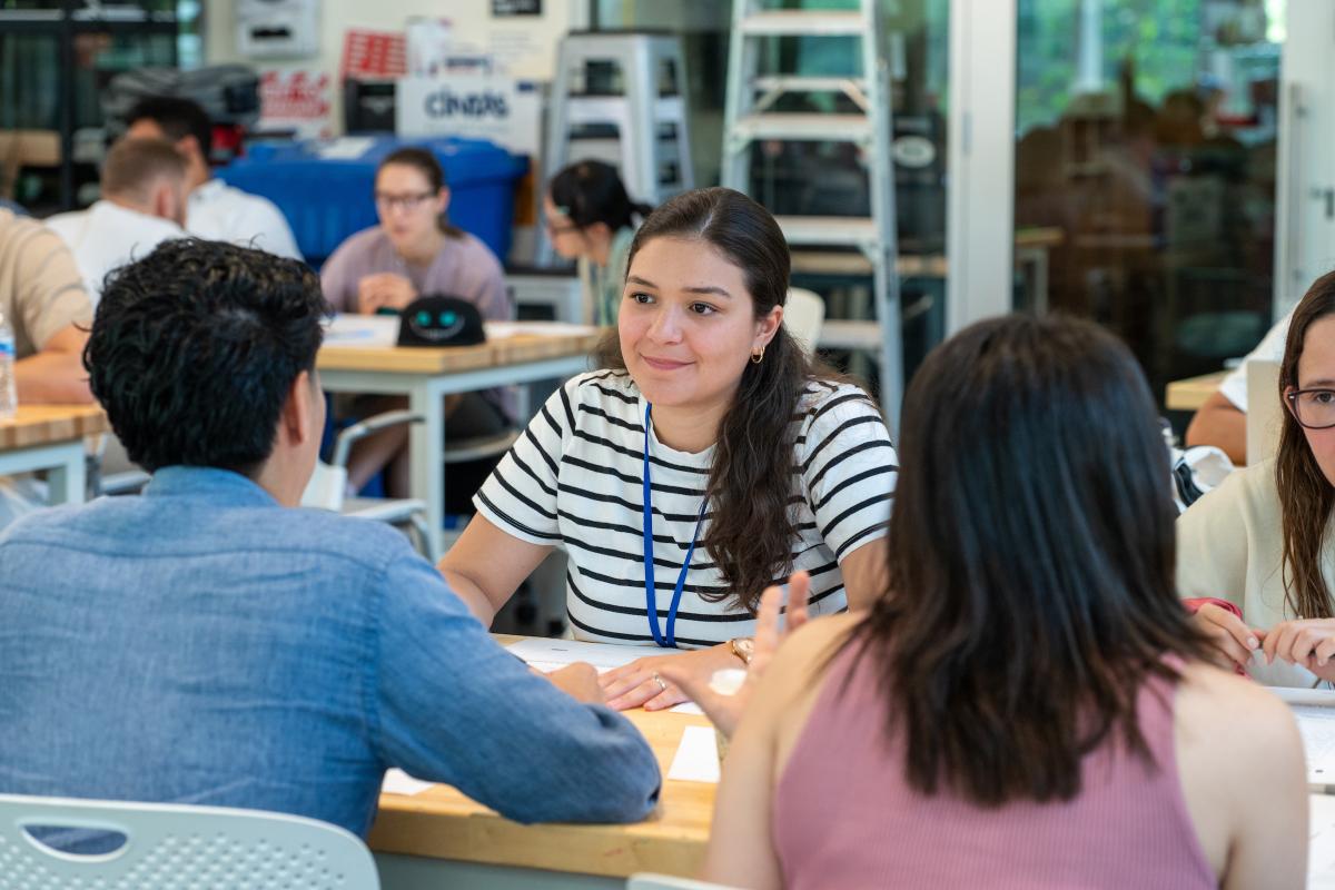 A photo of a woman sitting at a table with other people