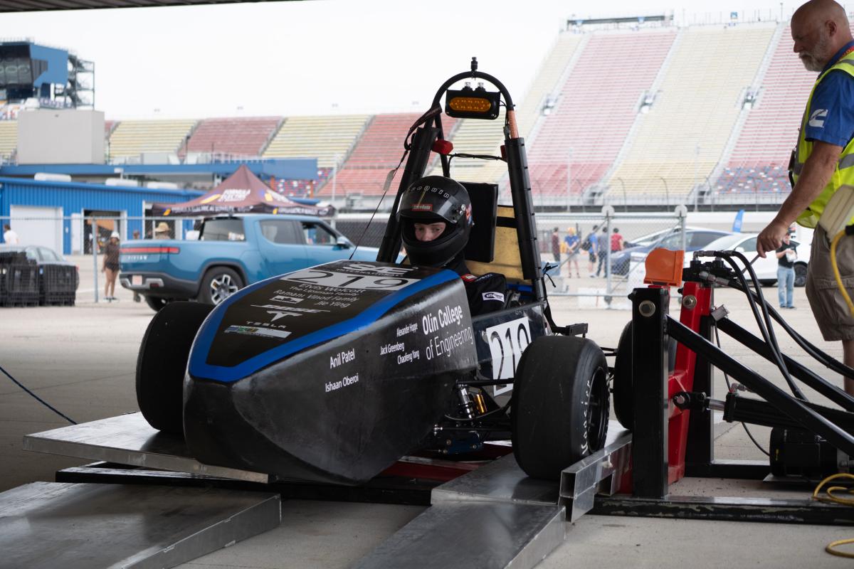 A member of the Olin Formula Project Team sits in the race car while taking part in a "tilt test" at a recent SAE competition. 